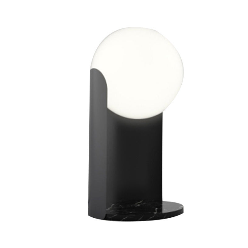Opal glass sphere lamp on black curved metal body