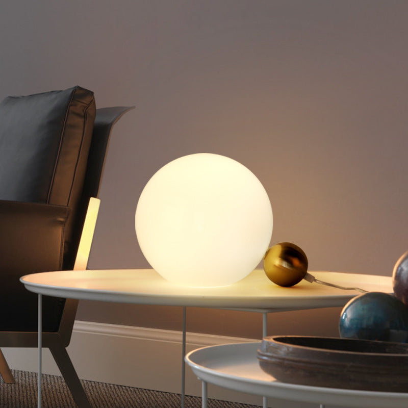 Postmodern opal globe lamp with brass satellite sphere styled beside lounge chair