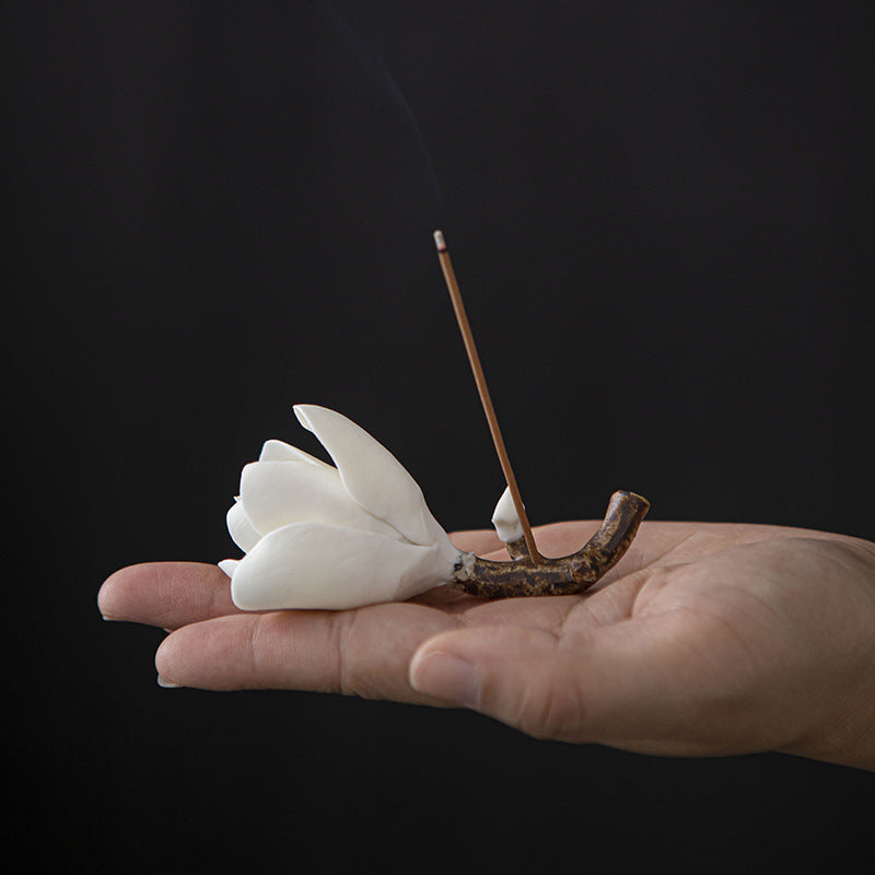 Compact ceramic magnolia incense holder shown in hand for scale