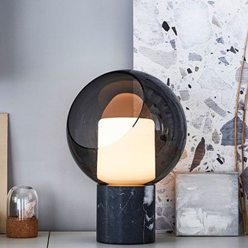 Smoked glass sphere lamp with warm inner cube and black marble base