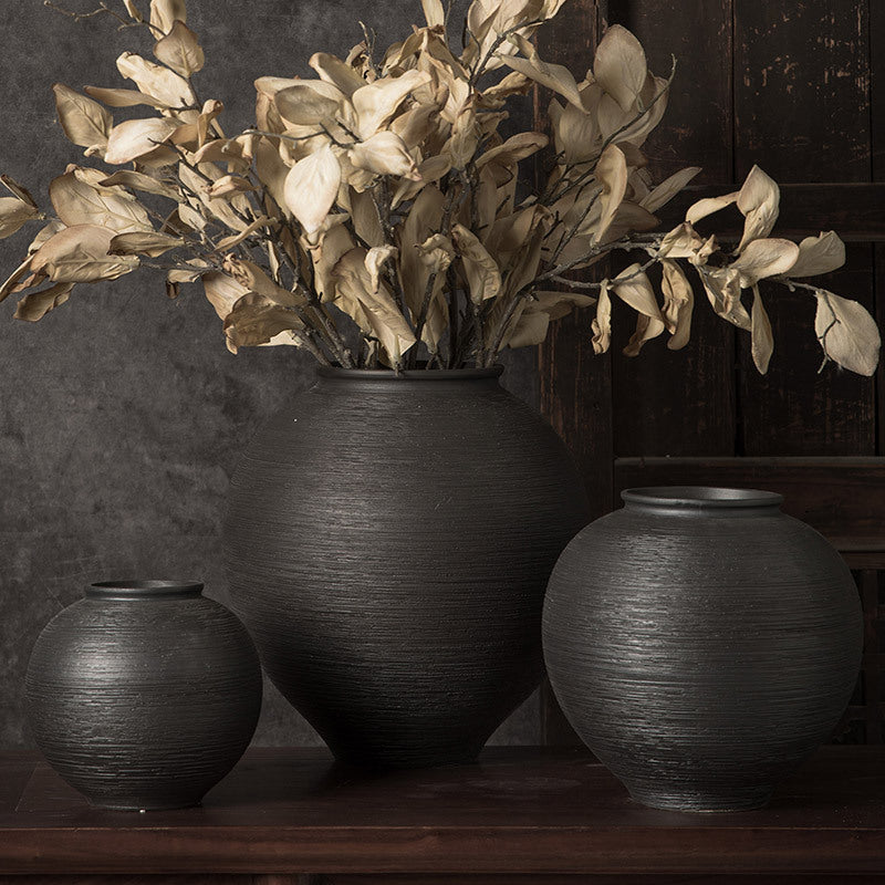 Black ribbed round ceramic vase set styled with dried foliage