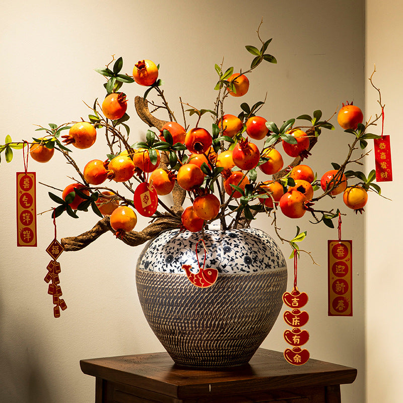 Blue and white floral ceramic jar with persimmon branch arrangement