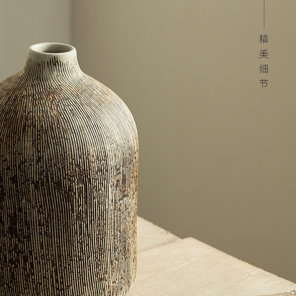 Close detail of vertically carved weathered ceramic vase surface