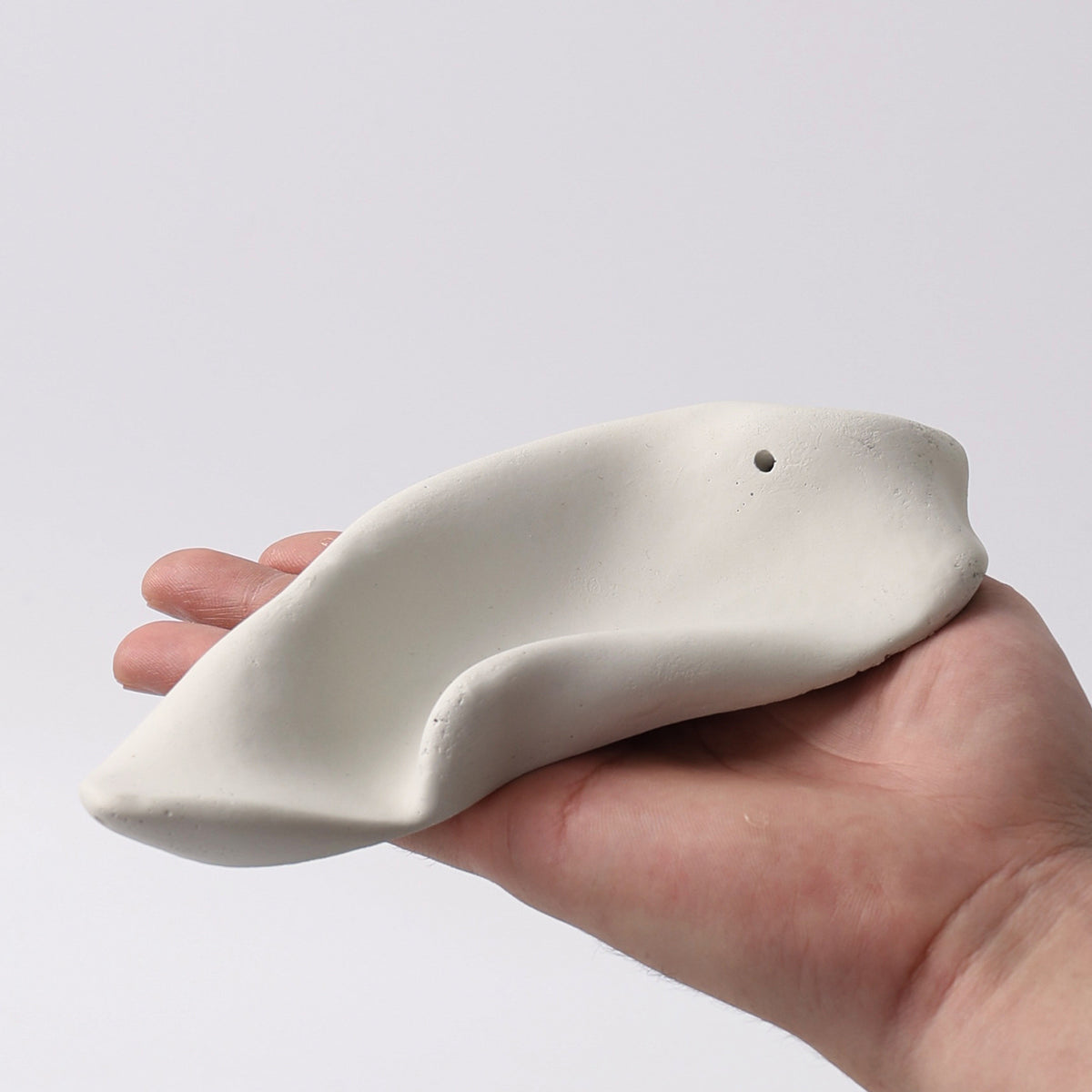 Ivory wrinkle ceramic incense holder shown in hand
