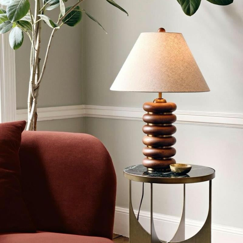 Walnut brown stacked disc table lamp styled beside rust sofa