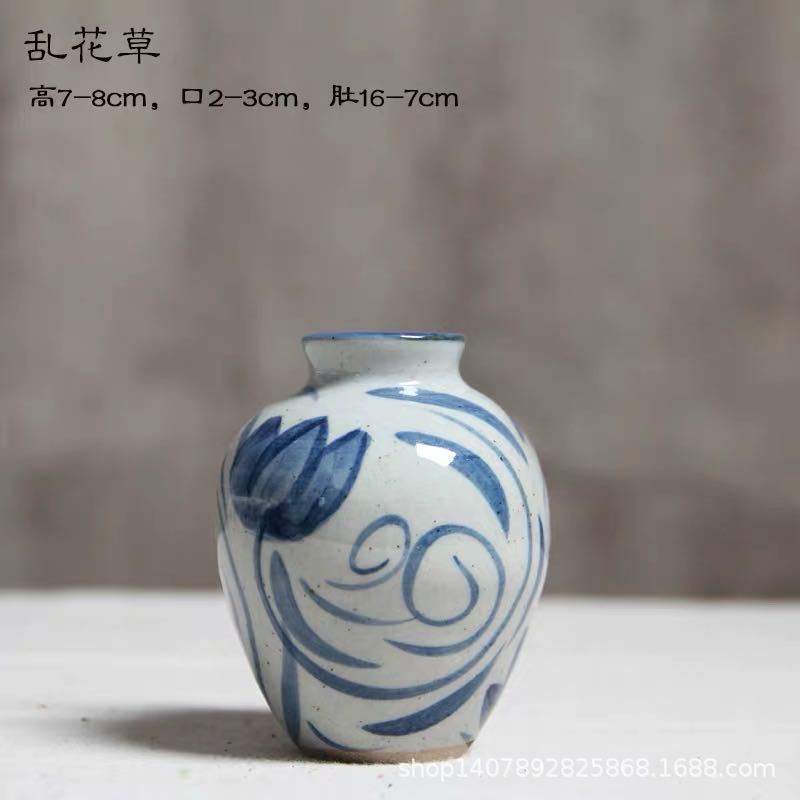 Hand-painted blue white ceramic bud vase with loose floral linework, small round shape