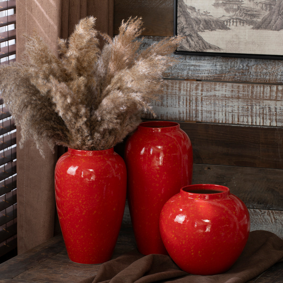 Red gold-speckled ceramic vase trio with dried grasses