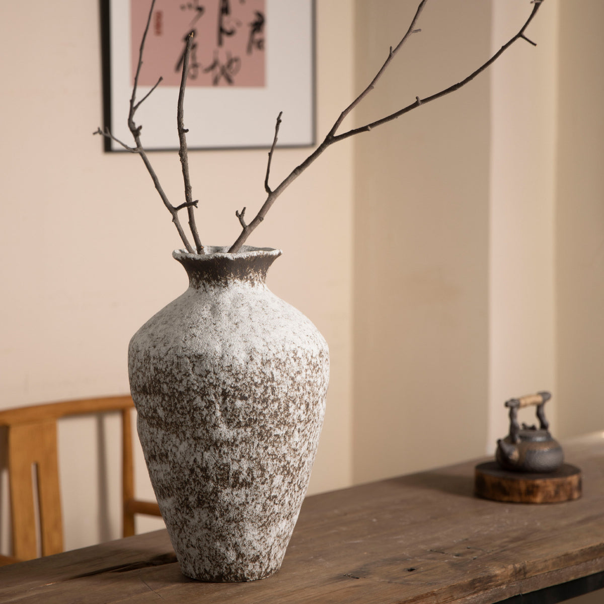Weathered white brown rustic ceramic vase styled with tall bare branches