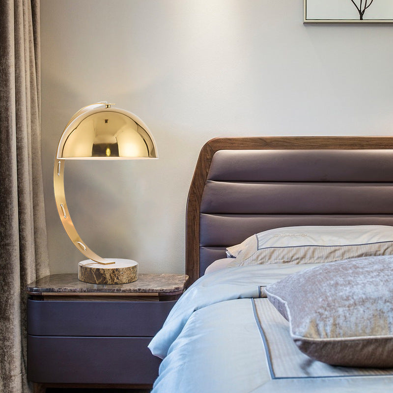 Brass arc dome bedside lamp styled in modern bedroom