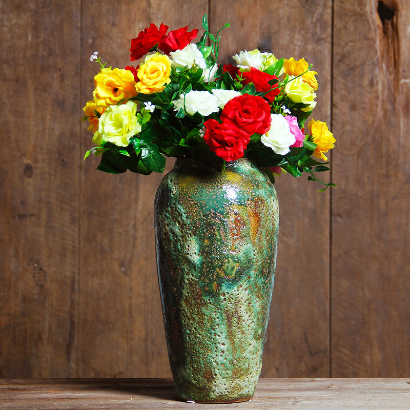 Green patina ceramic vase with colorful floral arrangement
