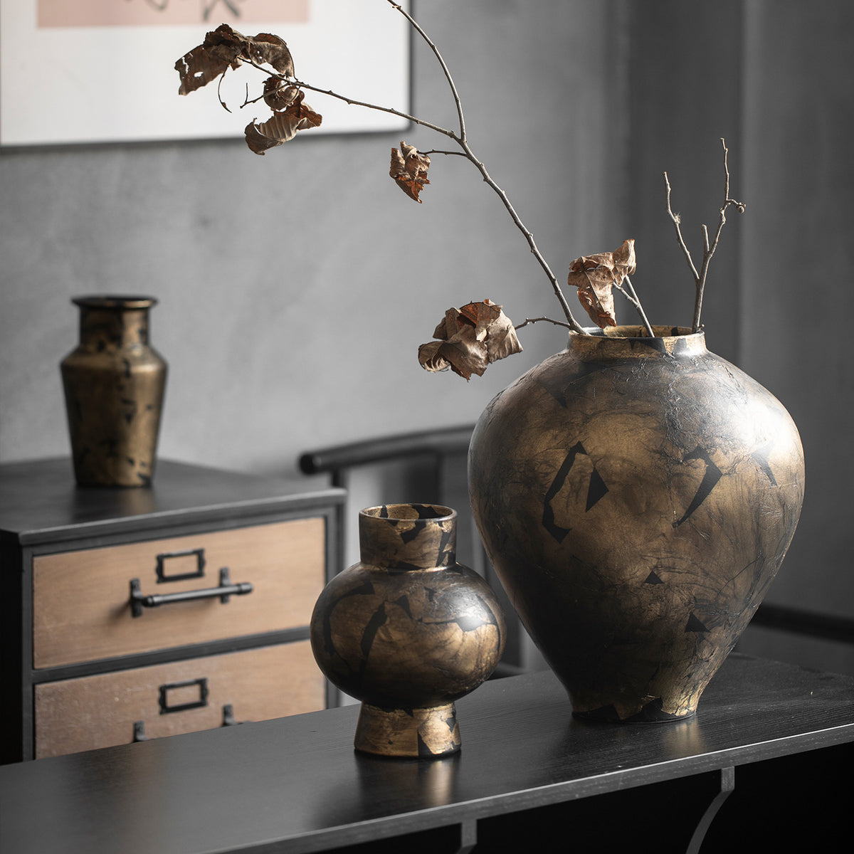 Large and small black gold crackle ceramic vases on console table