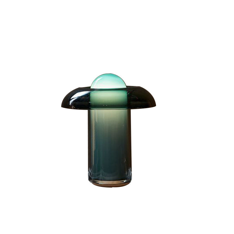 Green glass mushroom bedside lamp with softly glowing opal dome