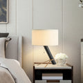 Postmodern leaning black column table lamp with ivory drum shade and brass support