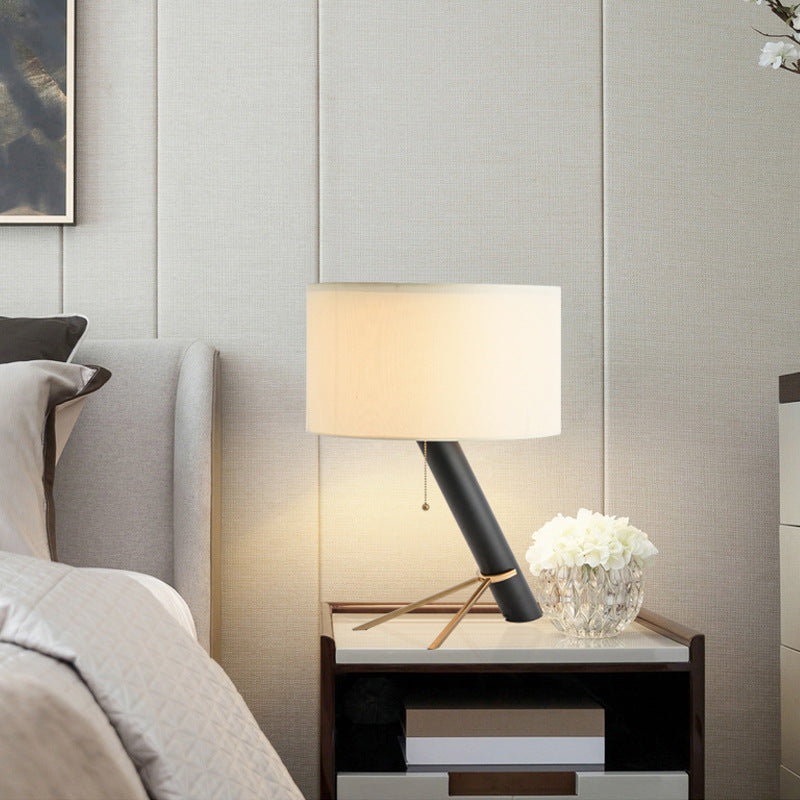 Postmodern leaning black column table lamp with ivory drum shade and brass support