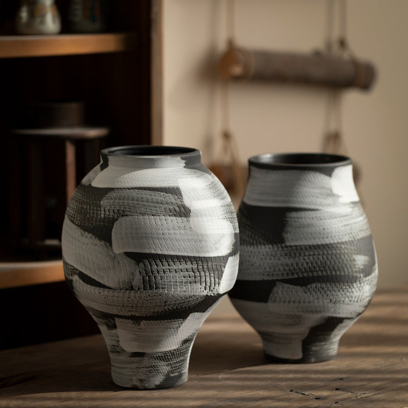 Two black and white sculptural ceramic vases styled together