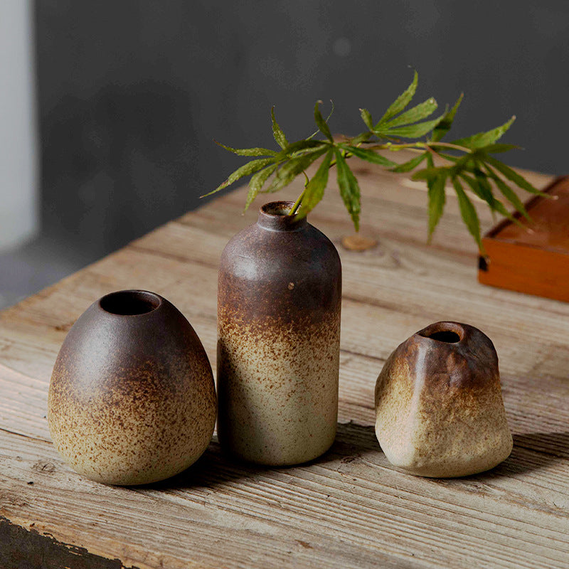 Brown-to-cream mini ceramic bud vase collection styled with green branches