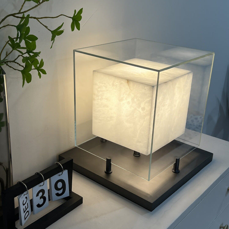 Small architectural glass frame table lamp on side table