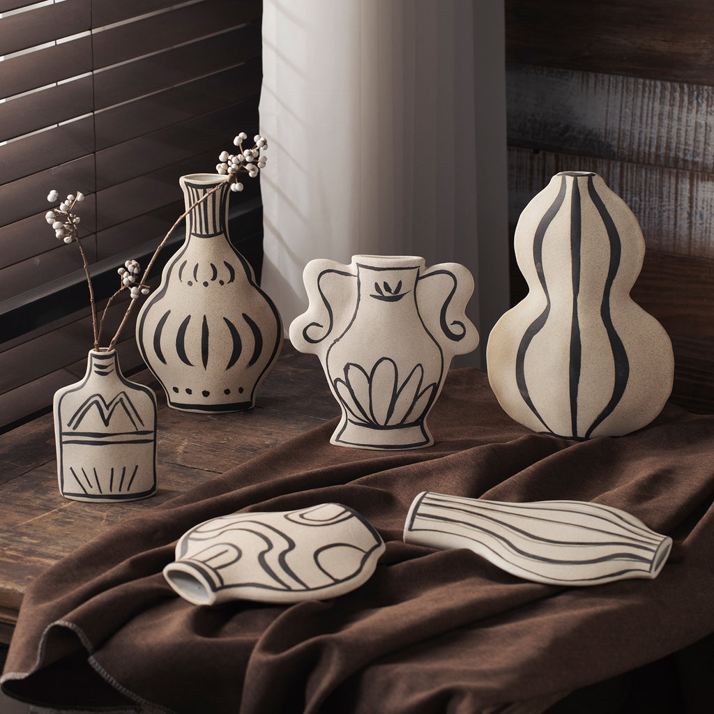 Ivory black-line art sculptural ceramic vase collection grouped together