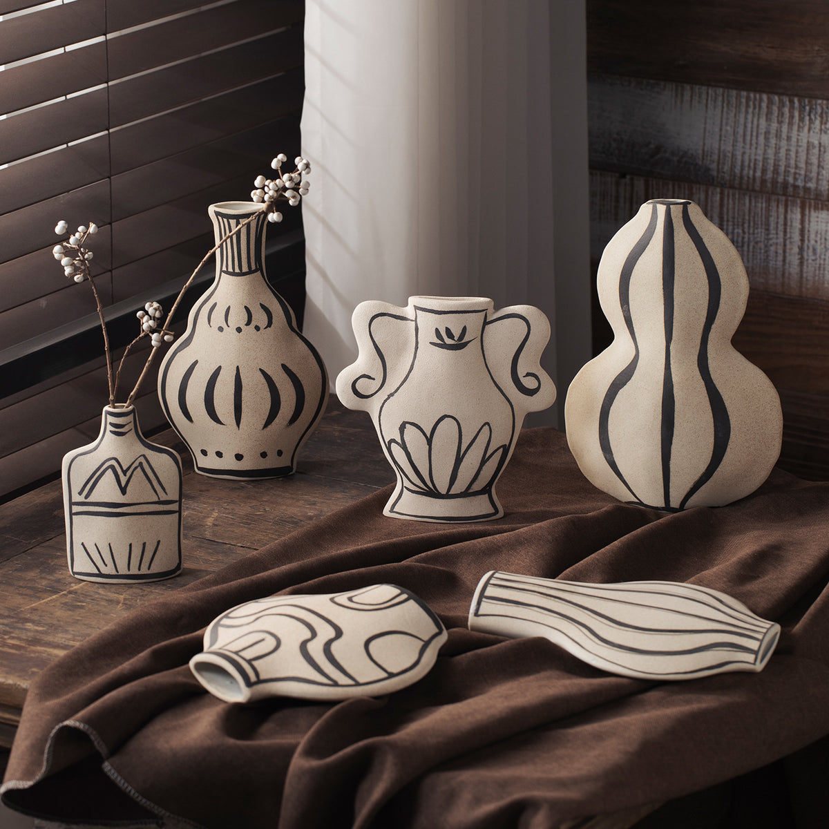 Ivory black-line art sculptural ceramic vase collection grouped together