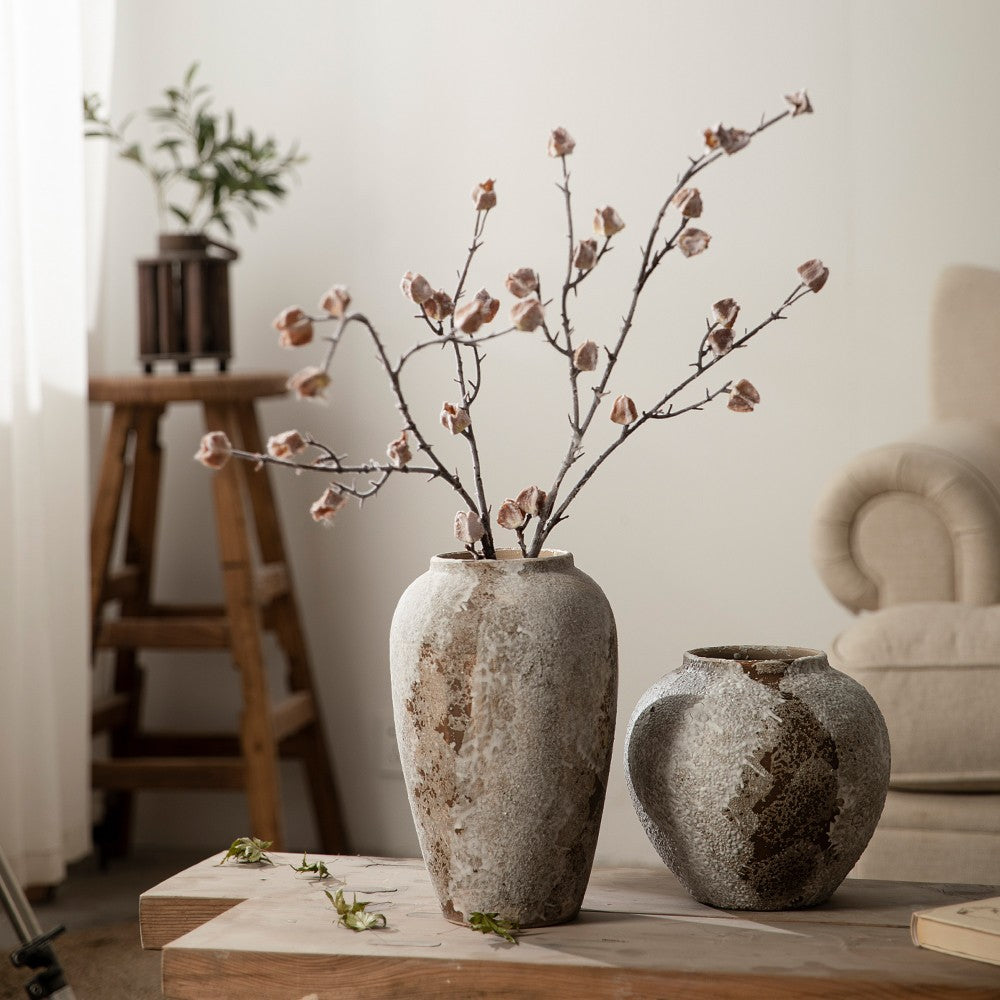 Tall and rounded aged ceramic vases styled with blossom branches