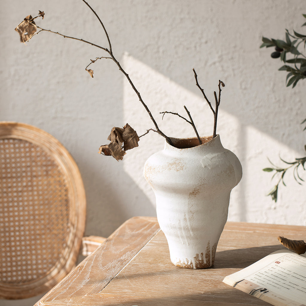 Tall aged white asymmetrical ceramic vase with branch arrangement