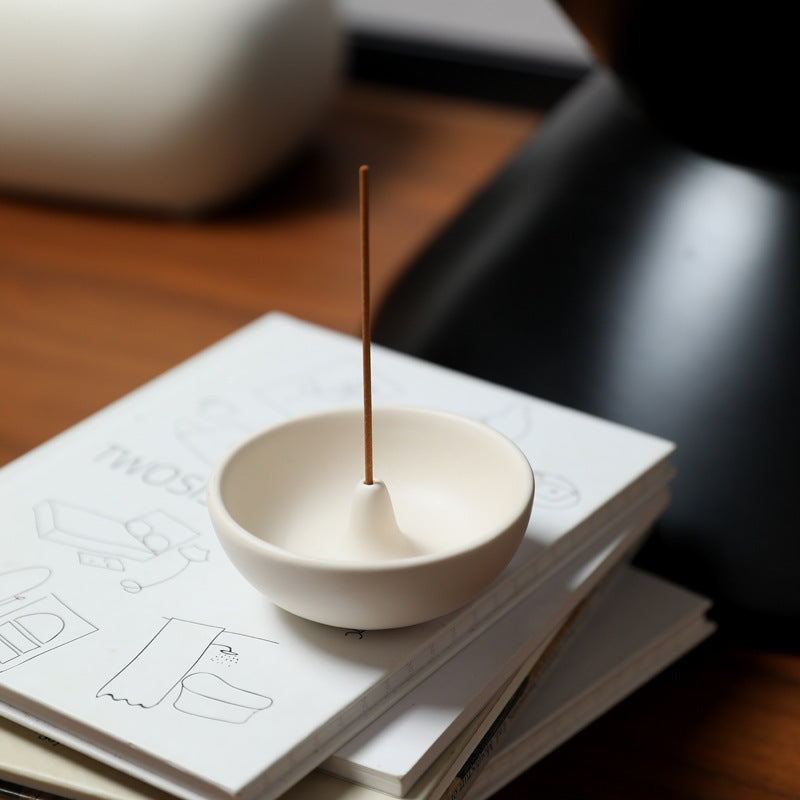 Japanese round ceramic incense holder on stacked design books