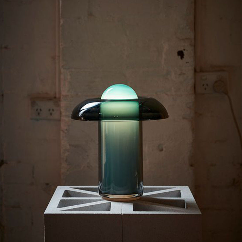 Teal green gradient glass table lamp glowing in dark interior