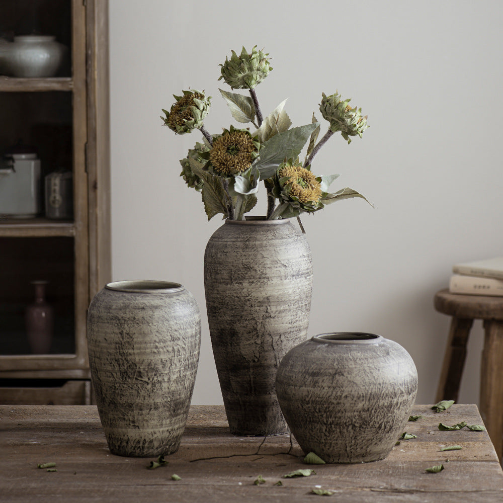 Three grey brown rustic ceramic vases styled with dried flowers