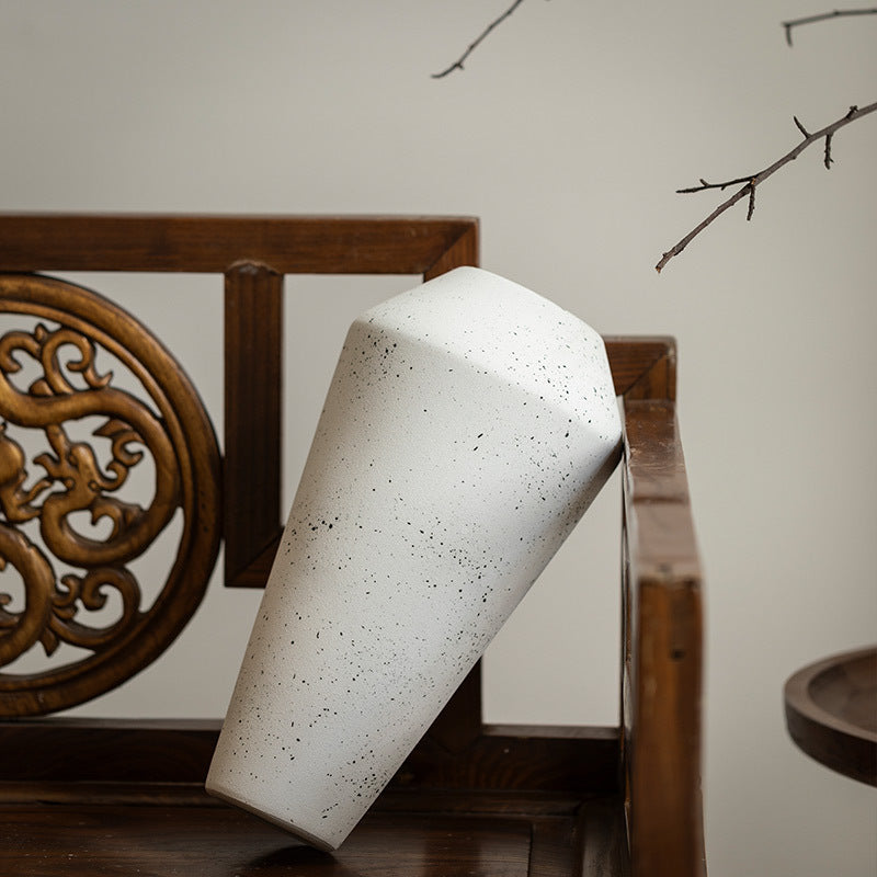 Ivory white faceted ceramic vase shown at an angle