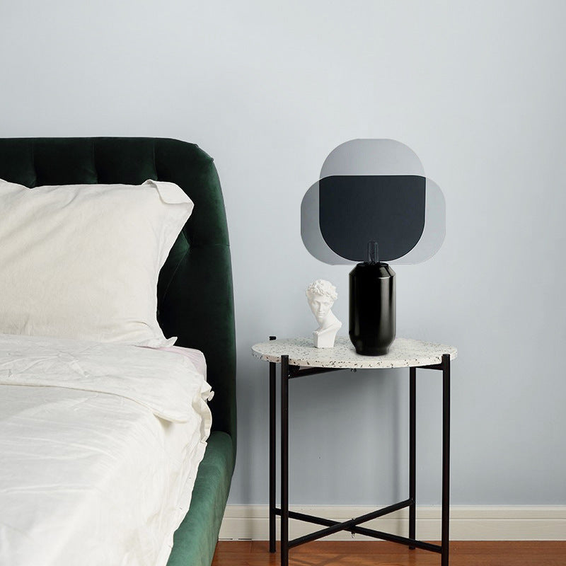 Overlapping smoke grey rounded acrylic panels table lamp on side table