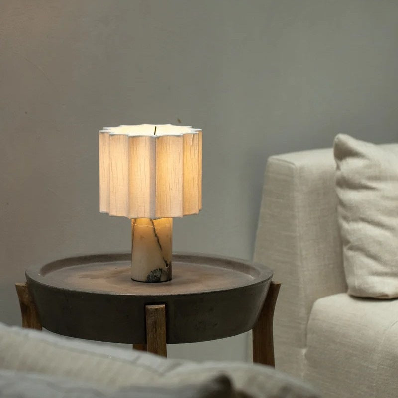Pleated shade Bulgari marble table lamp styled beside sofa