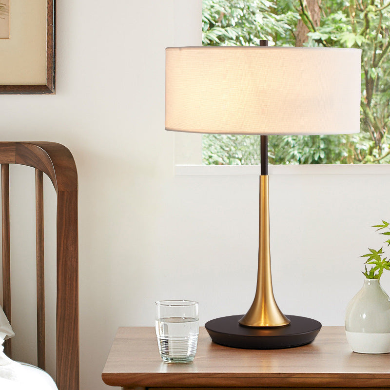 Mid century black brass table lamp with ivory fabric shade in bright interior