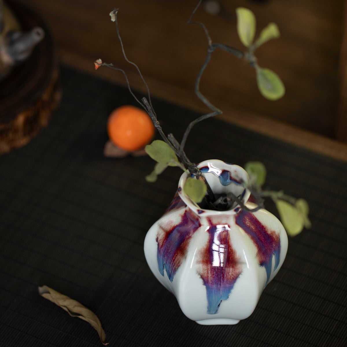 White rainbow drip-glaze ceramic bud vase close-up from above