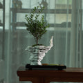 Sculptural black stone Zen micro landscape with layered white planter and ornamental tree