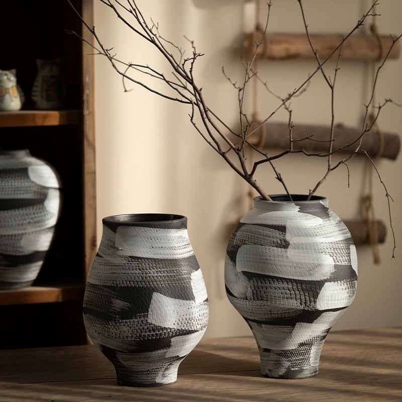 Two black and white textured ceramic vases with bare branches