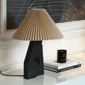 Black sculptural resin table lamp with pleated fabric shade