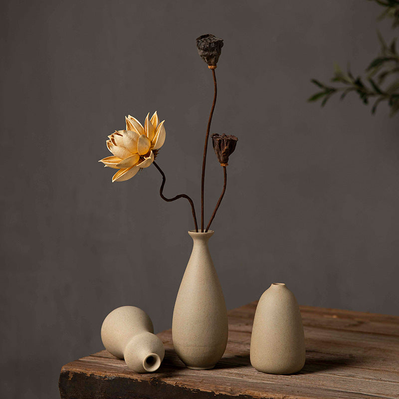 Three beige sculptural ceramic bud vases styled together