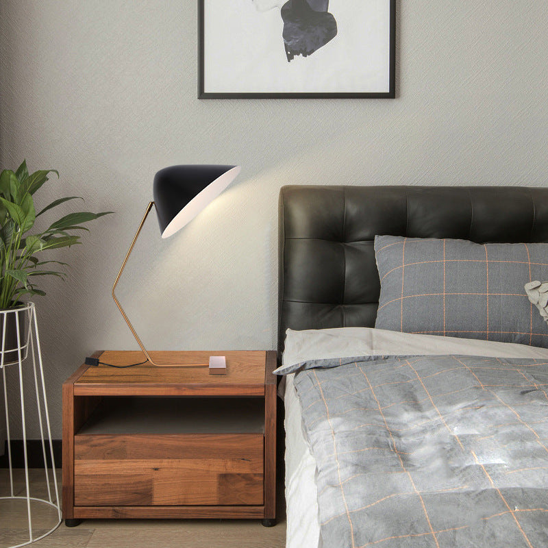 Mid century black cone table lamp with warm gold frame in living room