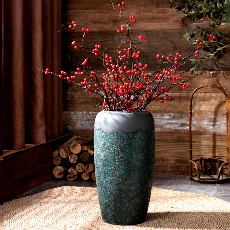Green patina ceramic floor vase with red berry branches