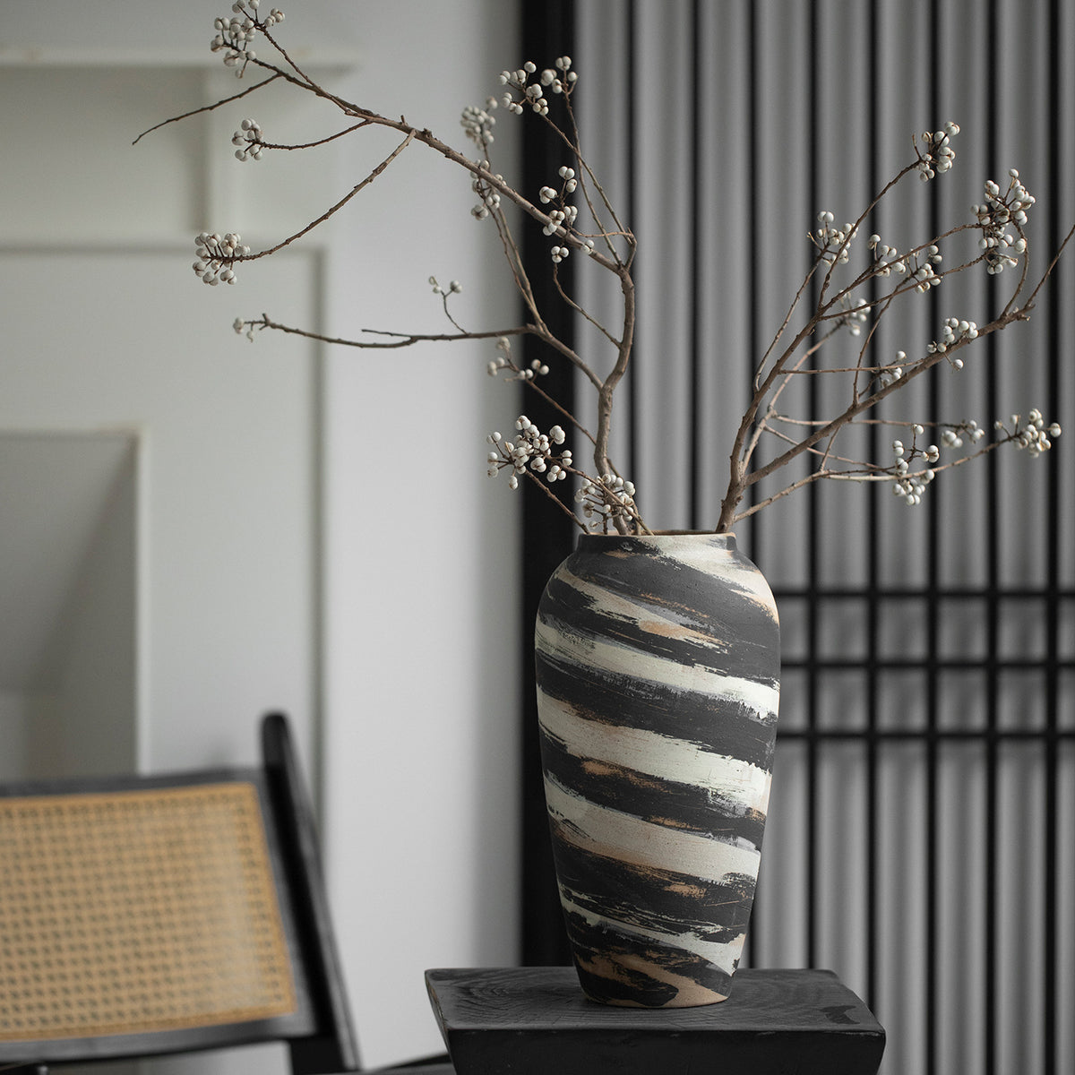 Tall charcoal cream striped ceramic vase styled with flowering branches