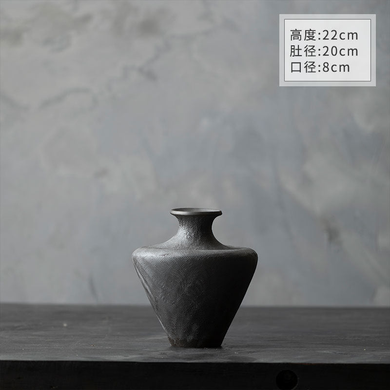 Matte black ceramic vase pair styled on dark wood console