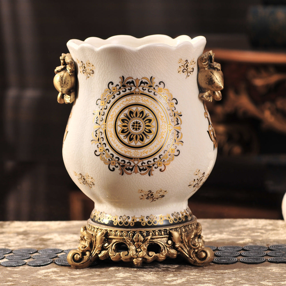 Vintage European ceramic vase with black and gold medallion pattern and ornate bronze-tone resin base