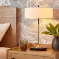 Black and brass table lamp with ivory drum shade styled on bedroom nightstand