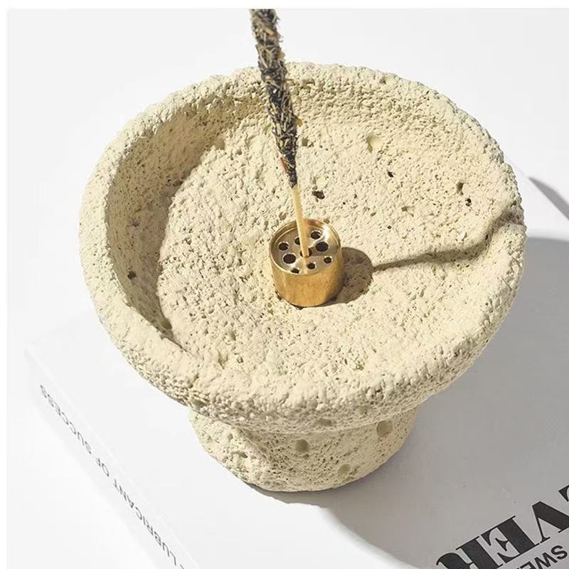Close view of porous sand beige incense bowl with brass multi-hole center