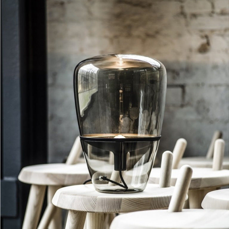 Smoke grey glass capsule lamp with black accessories in interior setting