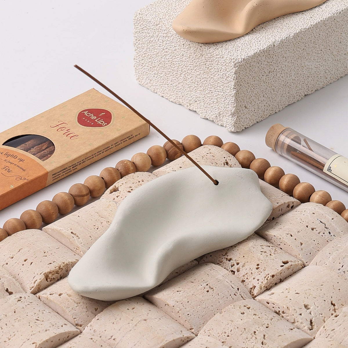 Ivory sculptural wrinkle ceramic incense tray styled with incense on stone blocks
