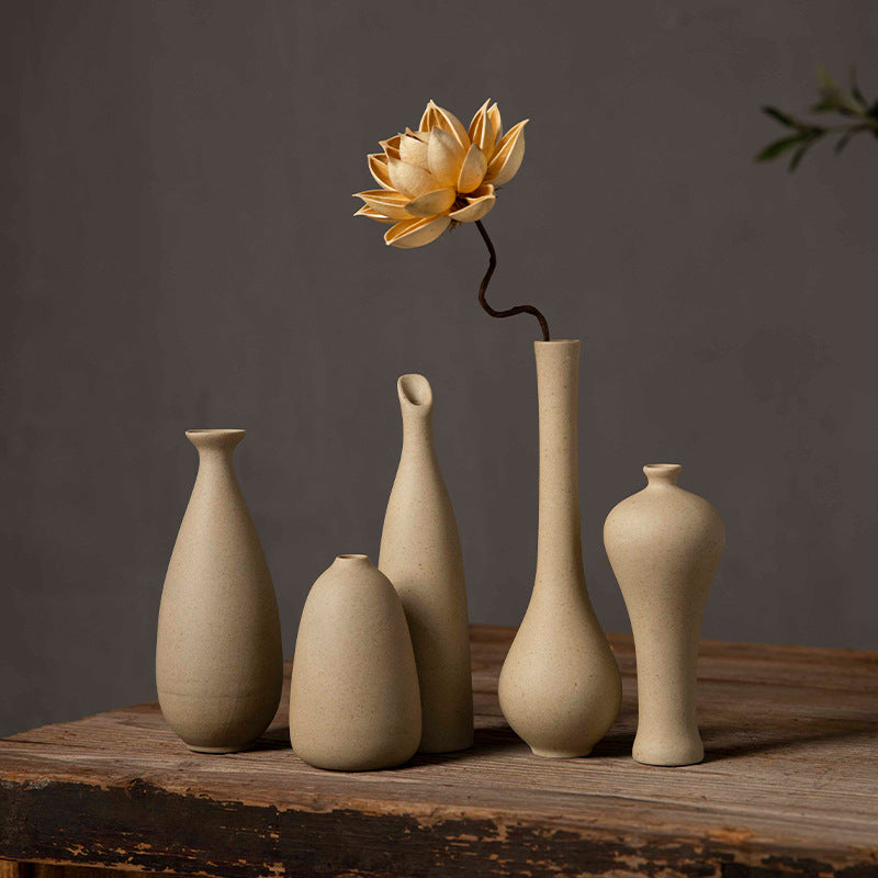 Five beige coarse-clay ceramic bud vase silhouettes styled together