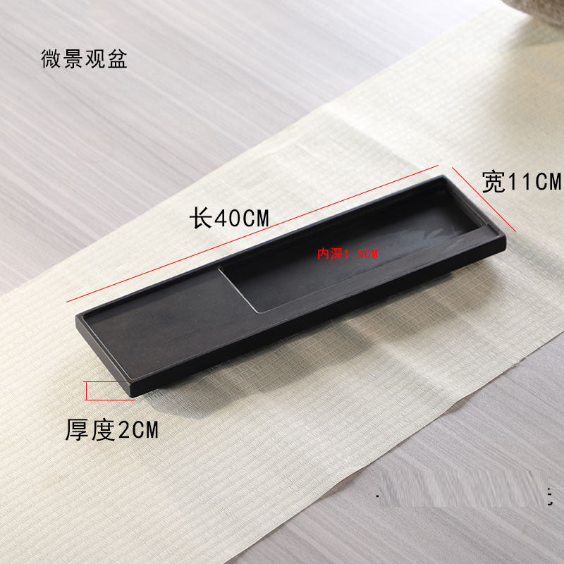 Long narrow black stone planter tray with raised sides