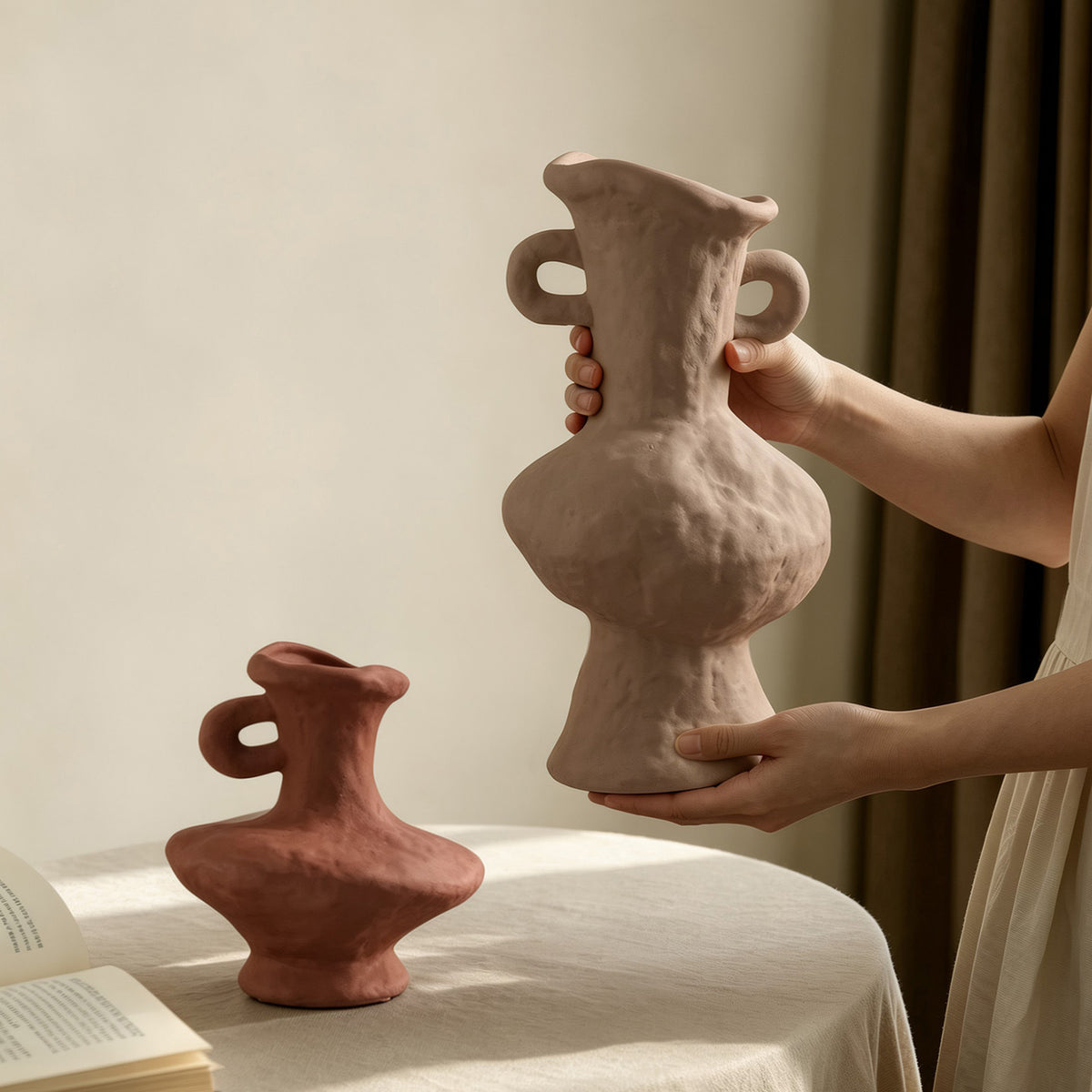 Rustic double-ear ceramic vases in ivory and terracotta held for scale