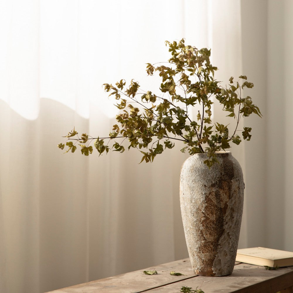 Large tall aged white brown ceramic vase with leafy branches